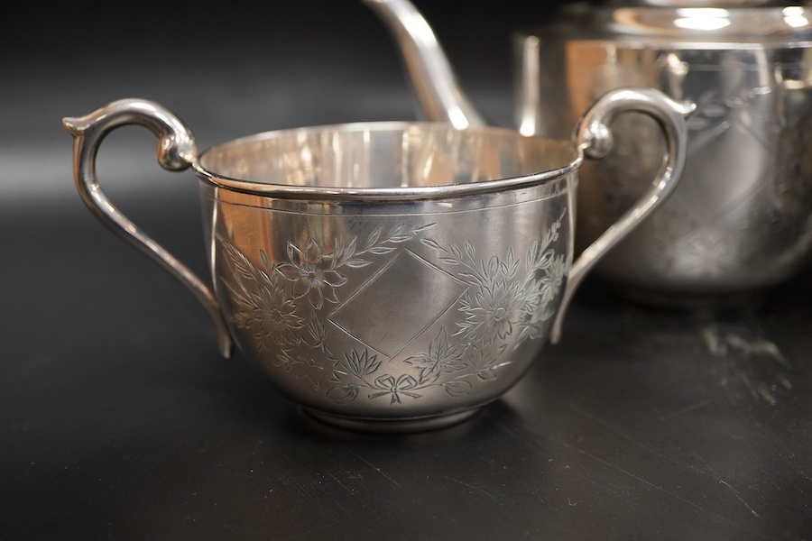 An Indian white metal three piece tea set, with engraved foliate decoration, gross weight 31.2oz.